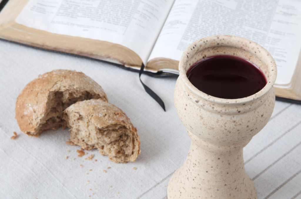 Biblia abierta con pan y cáliz de vino, símbolos de permanecer en Cristo